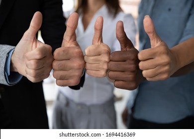 Close up view of diverse business team people hands showing thumbs up like finger gesture recommendation or good job choice. Professional multicultural team recommend corporate service.