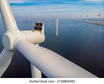close view with drone at windmill park in the lake Ijsselmeer in the netherlands Noordoostpolder, Windmill turbines from above in Europe producing green energy