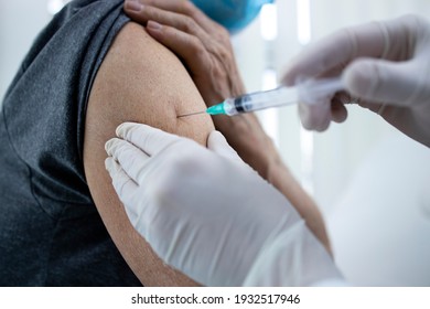 Close Up View Of An Elderly Man Getting Vaccine Shot In His Arm During Corona Virus Pandemic.