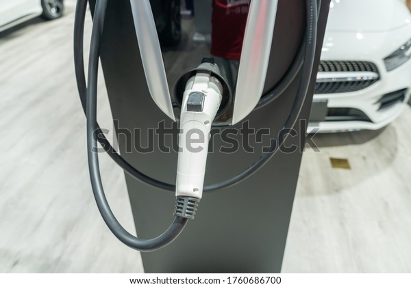 close up view of electric car\
charger   with blurred car background,selective\
focus.