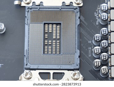 A close up view of an empty computer motherboard processor socket showing the intricate array of gold pins