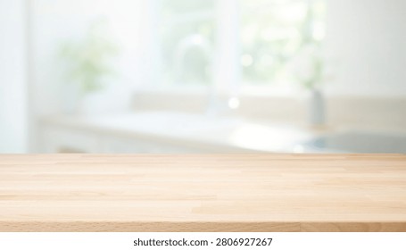 A close up view of an empty light wood tabletop surface with a soft focus blurry bright kitchen interior in the background ideal for product display
