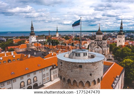 Close up view of the Estonian flag on top of the old medieval tower. 