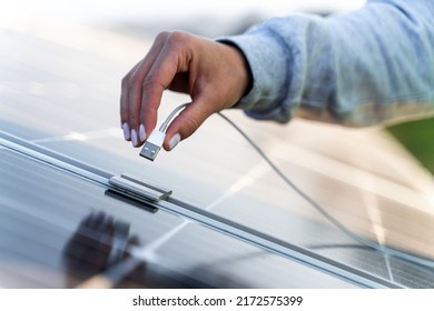 Close up view of female engineer charging mobile phone while working on maintenance of contemporary photovoltaic panels on solar power station  - Shutterstock ID 2172575399