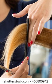 Close up view of female hairdresser hands cutting hair tips. Keratin restoration, healthy hair, latest hair fashion trends, changing haircut style, shorten split ends, instrument store concept - Shutterstock ID 468800942