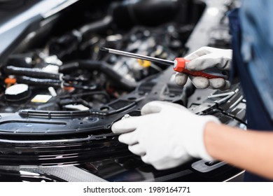 Close Up View Of Female Mechanic Hands In Gloves Repairing Car Motor With Screwdriver In Garage