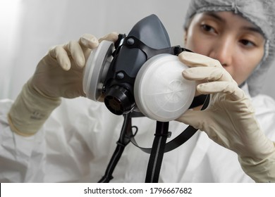 Close up view of a female nurse or a doctor inspecting a mask respirator.