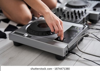 Close Up View Of The Female Songwriter Sitting At The Floor And Playing Dj Set At The Mixer While Making Tracks And Writing New Songs At Home. Music Concept