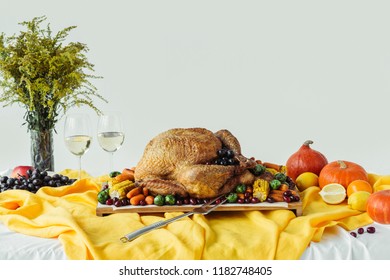 Close Up View Of Festive Thanksgiving Dinner Table Set With Glasses Of Wine, Roasted Turkey And Vegetables On Tabletop With Tablecloth