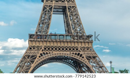 Close up view of first section of the Eiffel Tower with tourists on observation deck in Paris, France. Sunny summer day with blue clody sky