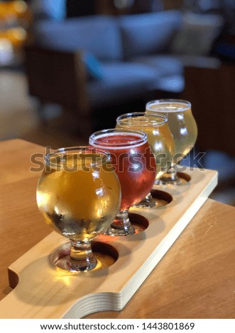 Close view of flight of various types of hard cider and beer on a wooden serving plank