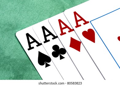 Close up view of four aces spread on a green cloth table.