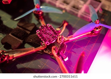 close up view of an fpv drone frame featuring vibrant propellers and intricate wiring, showcasing the components and design elements essential for drone enthusiasts and builders. neutral background