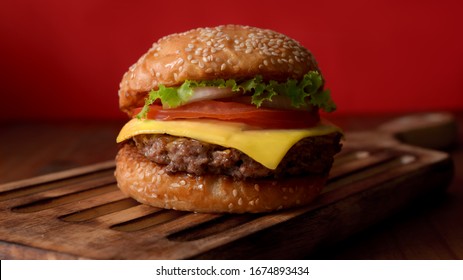 Close up view of Fresh tasty beef burger on wooden tray on rustic table white red wall background - Powered by Shutterstock