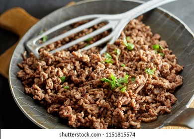 Close up view of fried minced meat on pan with green chives
