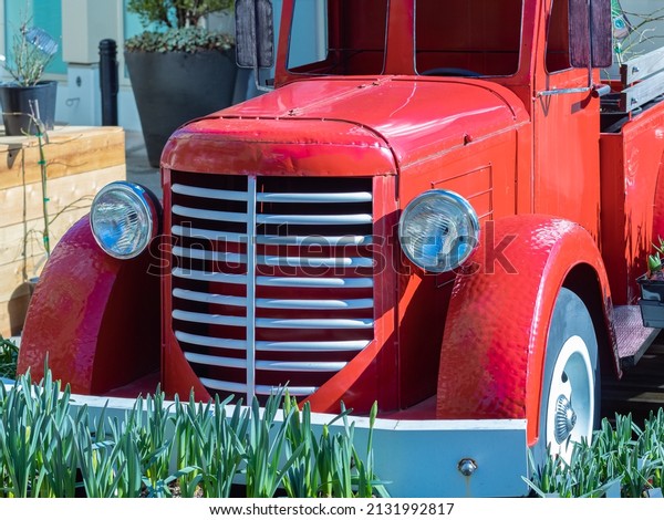Close up view of the front\
end of a beautifully restored vintage truck automobile. Old vintage\
American red pickup car front side. Nobody, street photo, selective\
focus