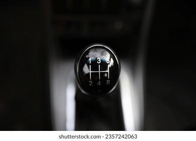 Close up view of a gear lever shift. Manual gearbox. Car interior details. Car transmission. Soft lighting. 