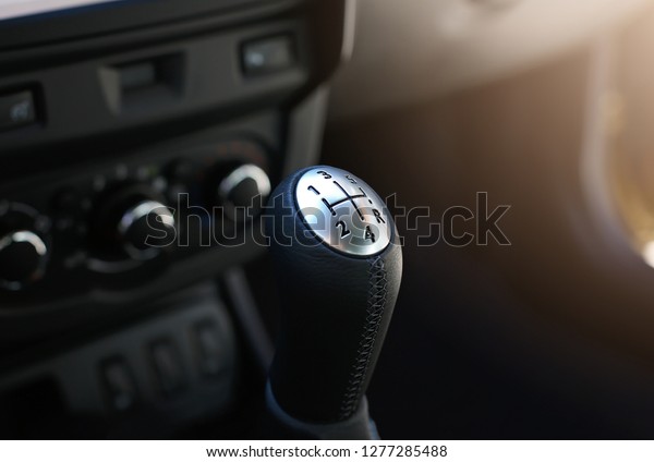 Close up view\
of a gear lever shift. Manual gearbox. Car interior details. Car\
transmission. Soft\
lighting.