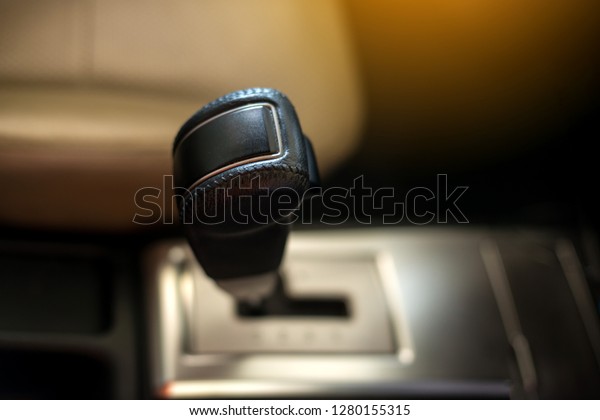 Close up view of a gear lever shift. Auto\
gearshift. Car interior details. Car transmission. Soft lighting.\
Abstract view.