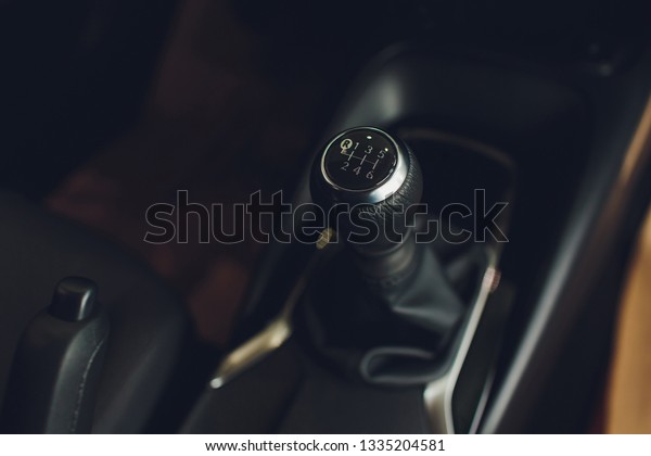 Close up view of a gear lever shift. Manual\
gearbox. Car interior details. Car transmission. Soft lighting.\
Abstract view.