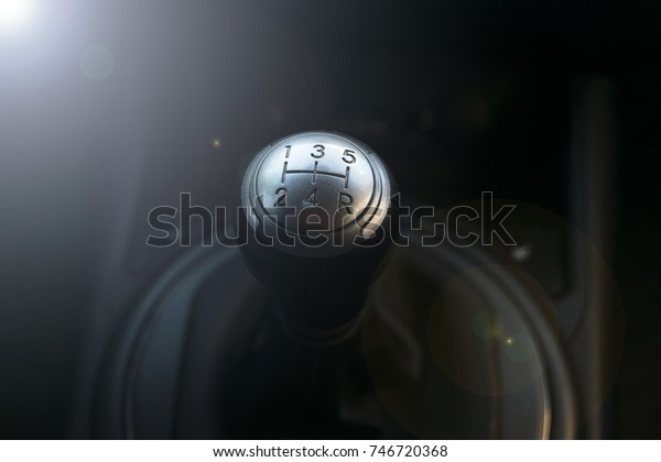 Close up view of a gear lever shift. Manual gearbox.\
Car interior details. Car transmission. Soft lighting. Abstract\
view