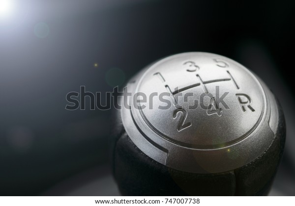 Close up view of a gear lever shift. Manual gearbox.\
Car interior details. Car transmission. Soft lighting. Abstract\
view