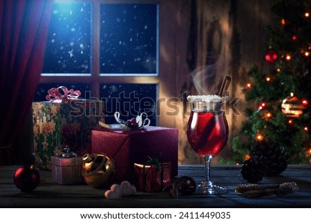 close up view of glass with mulled wine with gift boxes