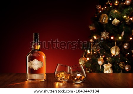 close up view  of glasses with whiskey  and bottle  on new year back