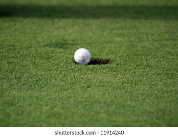 Close View Of A Golfball Just Falling In The Hole