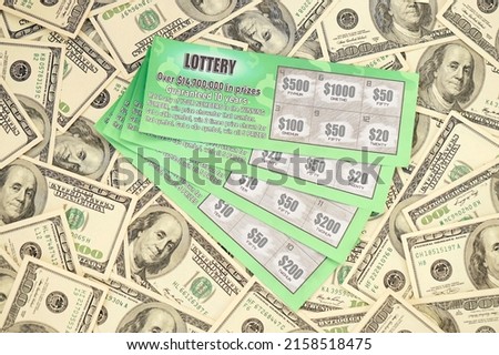 Close up view of green lottery scratch cards and us dollar bills. Many used fake instant lottery tickets with gambling results. Gambling addiction concept.