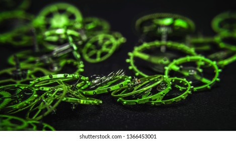 close view of a green toothed wheels watch mechanism with jewels