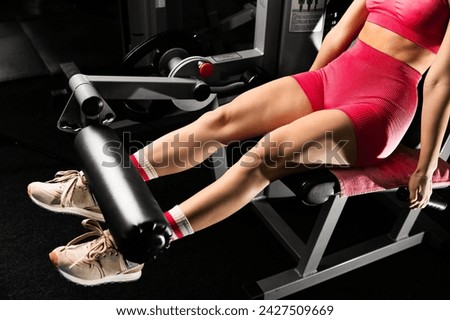 Close up view gym seated leg curl machine exercise woman at indoor in gym