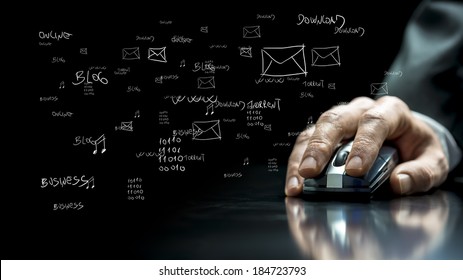 Close Up View Of The Hand Of A Businessman Using A Computer Mouse On A Reflective Black Surface With Hand-drawn Notations And Computer Icons On The Dark Background.