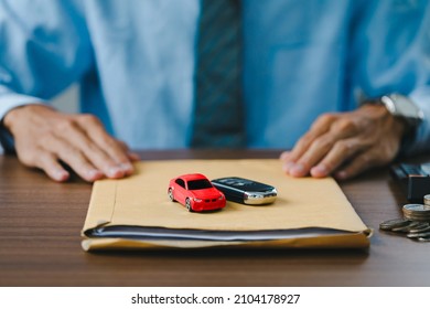Close up view Hand of car salesman Deliver the car and the car keys along with the documents to customers after who signed the purchase contract legally, Successful completion of car sales, 