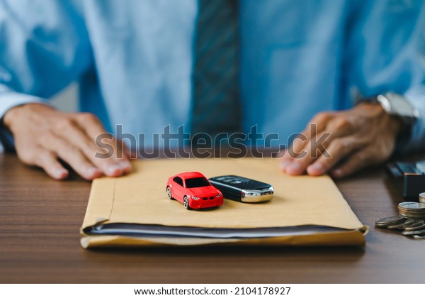Close up view Hand of car salesman Deliver the car\
and the car keys along with the documents to customers after who\
signed the purchase contract legally, Successful completion of car\
sales, \
\
