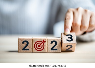 Close Up View Of Hand Flipping Cube Wooden 2022 To 2023 With Dartboard Icon, The End Of 2022 And The New Beginning In 2023, Concept Of Happy New Year, New Project, Opportunity, Goals, Strategy.