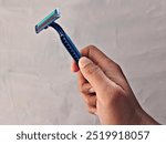 Close up view of hand holding manual shaver isolated on white background.