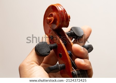 Close up view hand on Musical instrument acoustic guitar headstock adjust tuning pegs