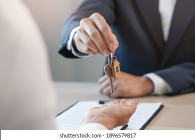 Close Up View Hand Of Property Realtor Landlord Giving A Key House To Buyer Tenant.