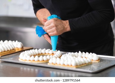 Close Up View, Hands Of The Chef With Confectionery Bag Cream Preparing A Fiftie Years Old Birthday Cake At Pastry Shop Kitchen .