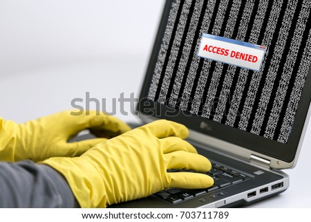 Close up View of Hands of Hacker working on Laptop to hack the Account password using yellow latex Gloves to avoid leaving fingertips