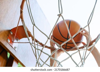 Close View Of Hands Throwing A Ball Into A Basketball Hoop, Teenage Boy Playing At Home In The Backyard, Outdoor Activities On Summer Vacation