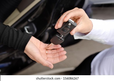 Close Up View Of The Hands Of A Woman Handing Over A Set Of Car Keys To A Second Woman Holding Out Her Hand, Conceptual Image