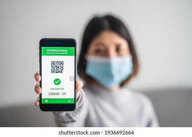 close up of view hands women holding smartphone display on app mobile vaccinated COVID-19 or coronavirus certificate, immunity vaccine passport, new normal travel of tourist concept.