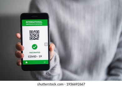 close up of view hands women holding smartphone display on app mobile vaccinated COVID-19 or coronavirus certificate, immunity vaccine passport, new normal travel of tourist concept.