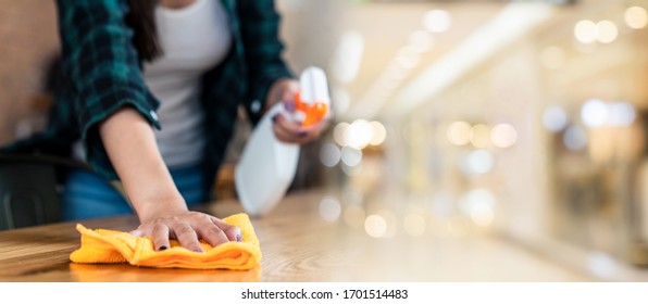 Close Up View Of Happy Woman Clean Home Or Restaurant. She Wiping Dust Using Spray And Orange Fabric Cleaning On Dirty Table. House Keeping Maid Cleaning Service Job To Prevent Covid19 Virus Outbreak.