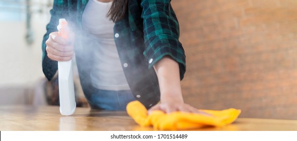 Close Up View Of Happy Woman Clean Home Or Restaurant. She Wiping Dust Using Spray And Orange Fabric Cleaning On Dirty Table. House Keeping Maid Cleaning Service Job To Prevent Covid19 Virus Outbreak.