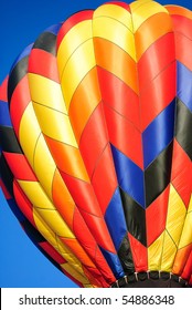 A Close Up View Of An Hot Air Ballon With Rainbow Colors With Blue Sky