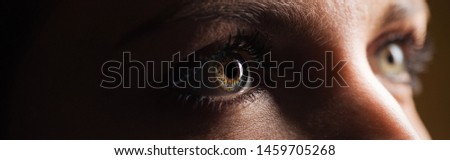 close up view of human eye looking away in dark, panoramic shot