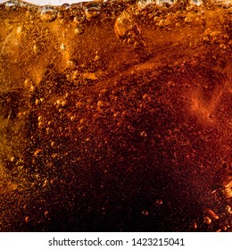 Close up view of the ice cubes in dark cola background. Texture of cooling sweet summer's drink with foam and macro bubbles on the glass wall. Fizzing or floating up to top of surface. - Shutterstock ID 1423215041